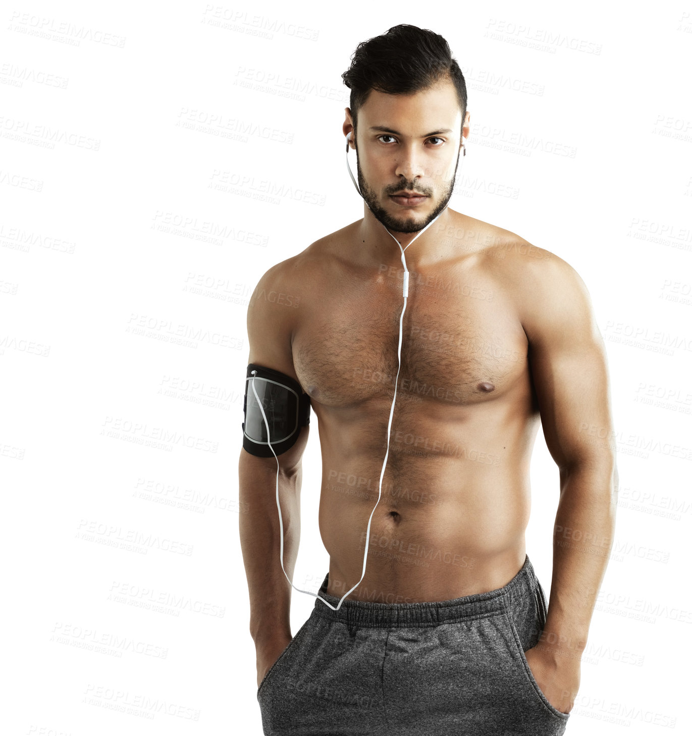 Buy stock photo Cropped studio portrait of an athletic young man listening to music through earphones