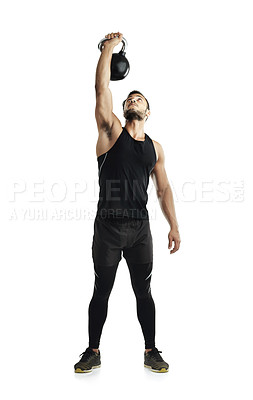 Buy stock photo Studio shot of a fit young man working out with a kettle bell against a white background