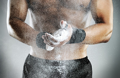 Buy stock photo Cropped studio shot of a man dusting his hands with chalk before a fight