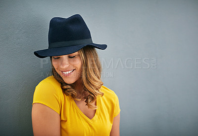 Buy stock photo Woman, smile and hat by gray background with fashion inspiration, clothes and mockup for marketing. Happy, confidence and face of gen z person by dark wall with advertising space, fedora and style