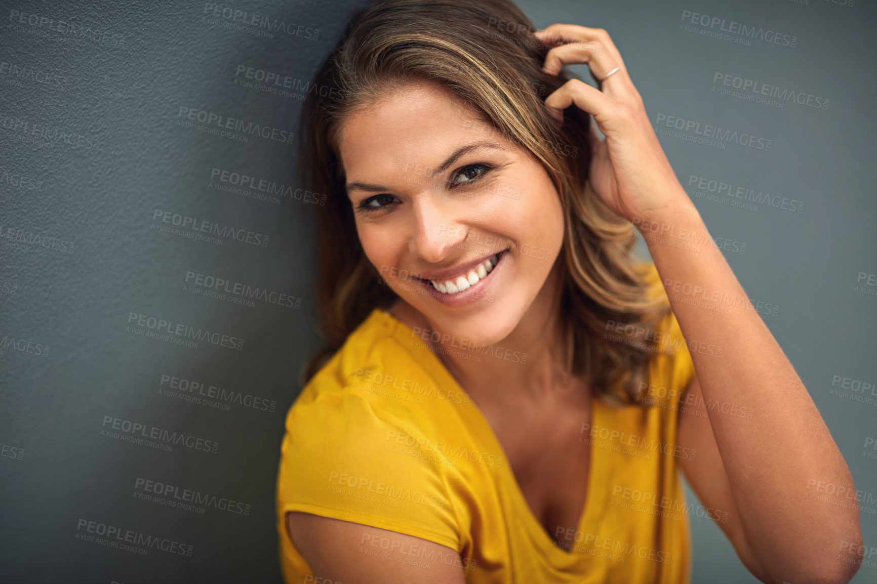 Buy stock photo Shot of a young woman posing against a gray wall