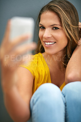 Buy stock photo Confident, woman and smile with selfie in studio for social media post, update and online blog. Influencer, relax and happy in photography for content creation, pride and memory on grey background