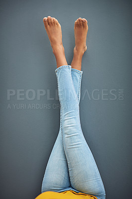 Buy stock photo Shot of a woman's crossed legs leaning against a gray wall