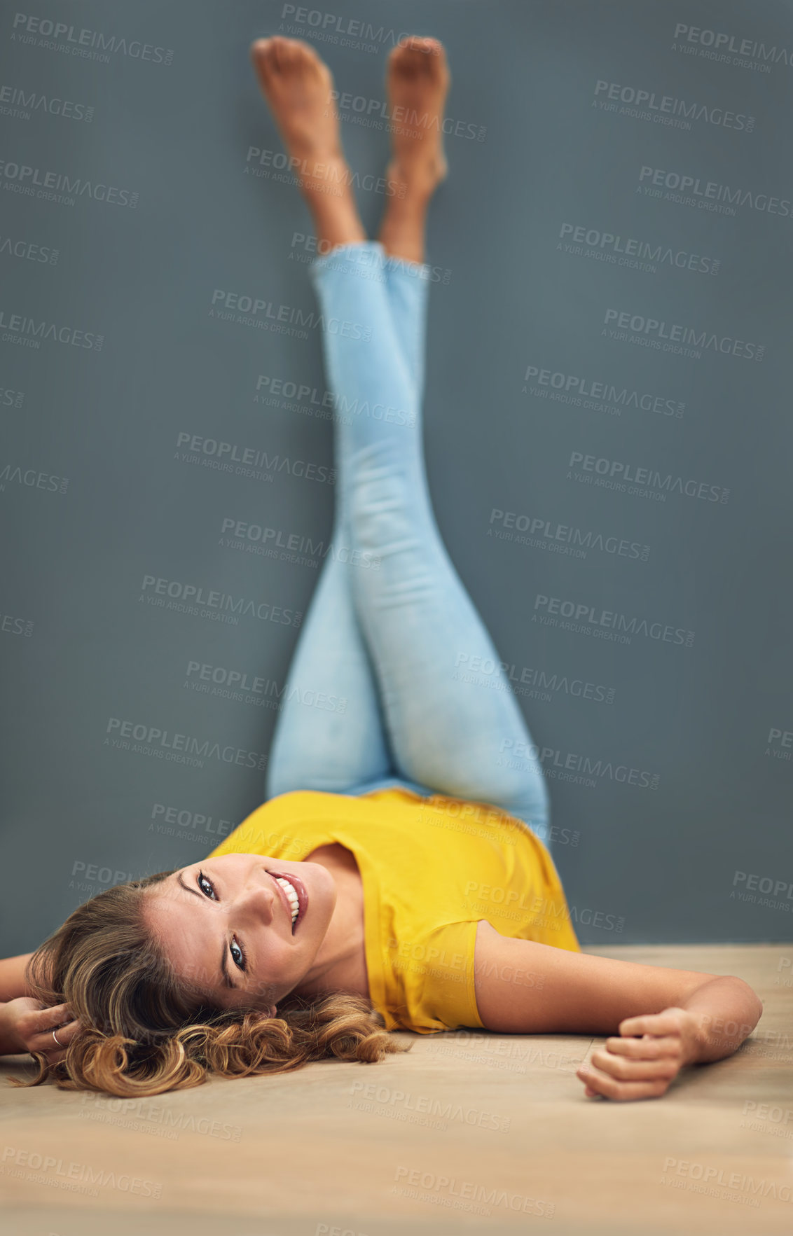 Buy stock photo Woman, floor and portrait by studio background with legs up, relax aesthetic and mockup for marketing. Happiness, body pose and gen z model by dark backdrop with yellow color and advertising space