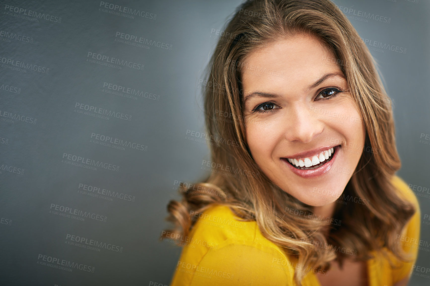 Buy stock photo Shot of a young woman posing against a gray wall