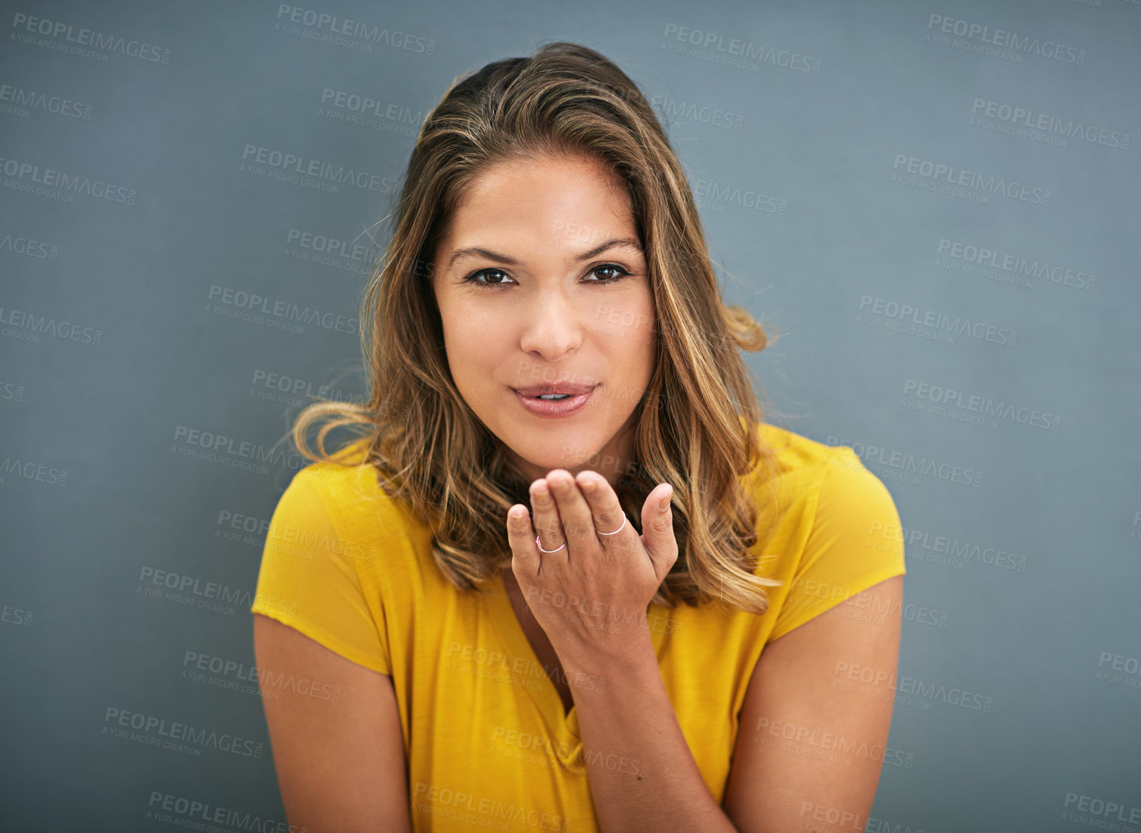 Buy stock photo Woman, blowing a kiss and portrait with studio, love and smile for romance isolated on grey background. Model, hand and gesture for affection, flirt and emoji for valentines care and happiness