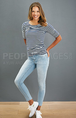 Buy stock photo Portrait of a young woman posing against a gray wall