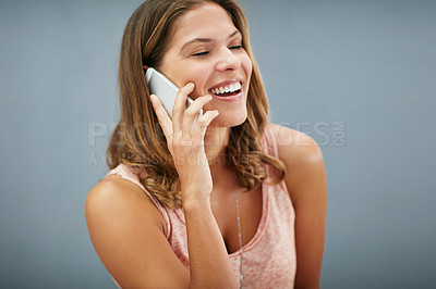 Buy stock photo Laughing, phone call and happy woman talking in studio for story, gossip or news discussion isolated on a gray background. Mobile, smile and funny model in conversation, chat and listening to contact