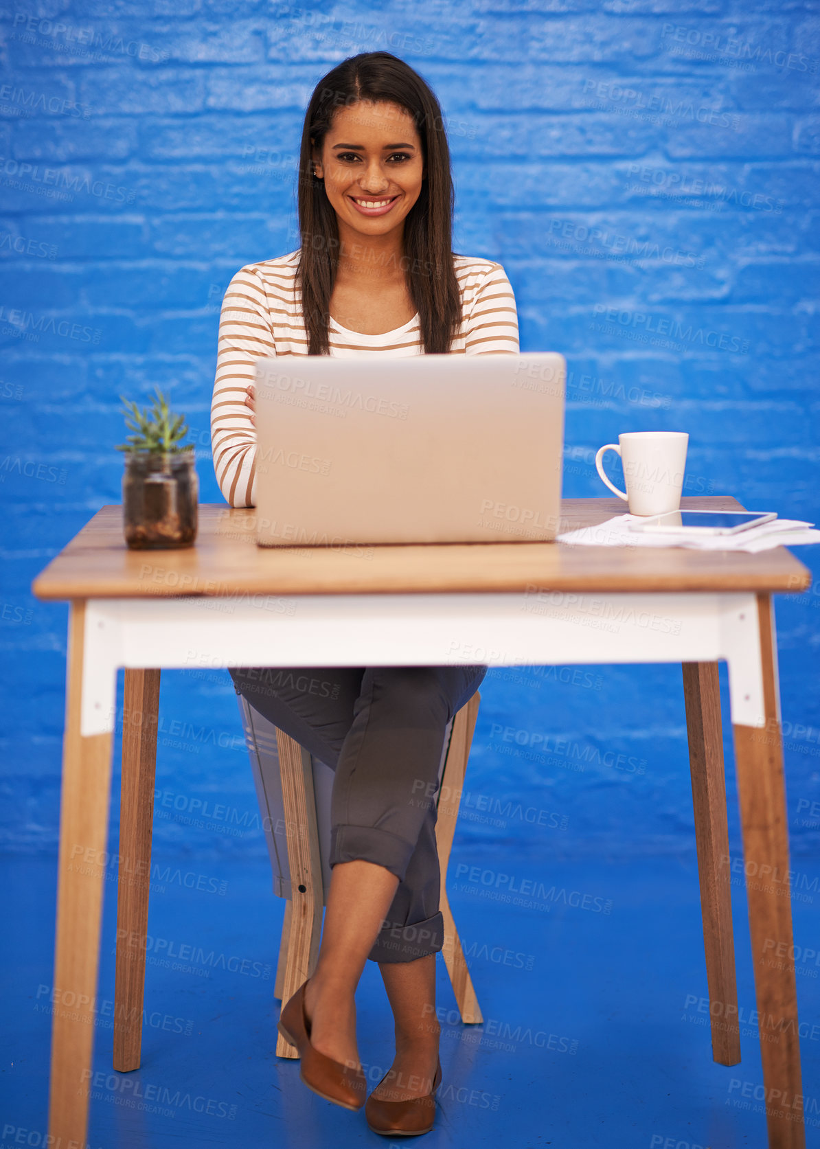 Buy stock photo Smile, laptop and portrait of woman by wall with desk for startup journalism company with creative career. Happy, computer and female person from Mexico work on copywriting online article in office.