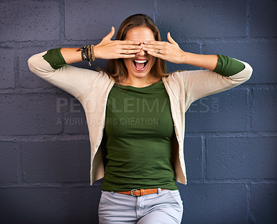 Buy stock photo Shot of a young woman covering her eyes against a brick wall background