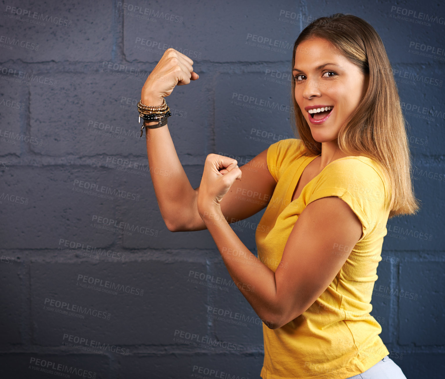 Buy stock photo Cropped portrait of a young woman putting up her fists against a brick wall background