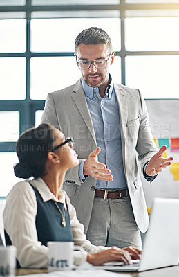 Buy stock photo Cropped shot of a businessman explaining something to a female colleague