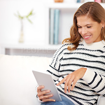 Buy stock photo Shot of a young woman using her digital tablet at home