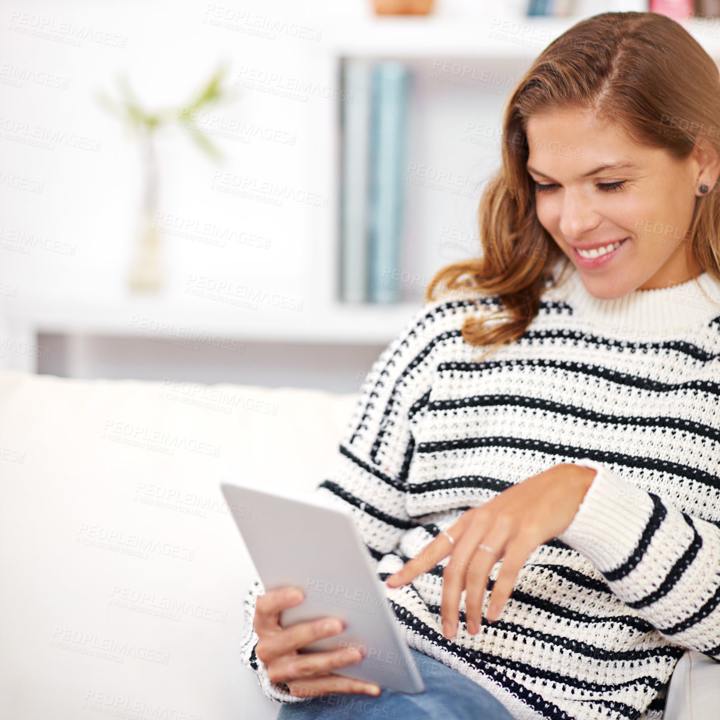 Buy stock photo Shot of a young woman using her digital tablet at home