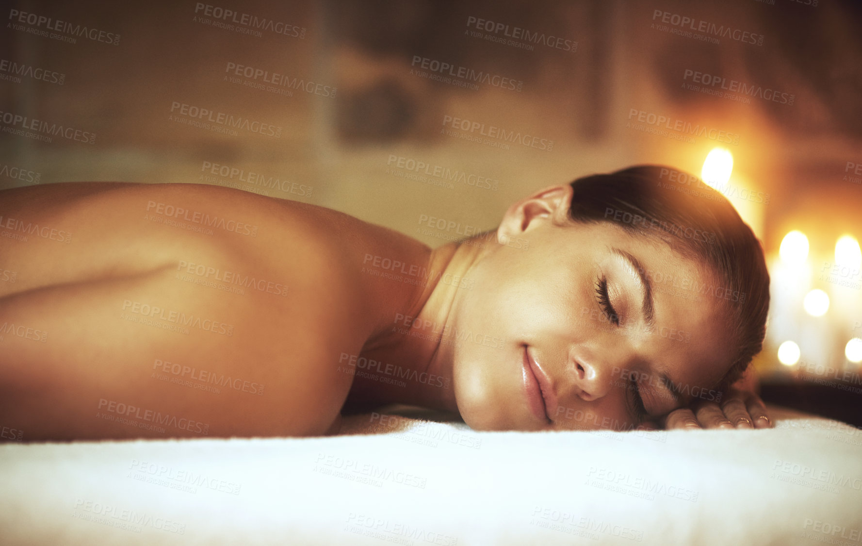 Buy stock photo Woman, relax and zen in spa on massage bed for glow, wellness and cosmetics with candles. Treatment, beauty and sleep with peace after aromatherapy, deep tissue and stress relief with oil for luxury