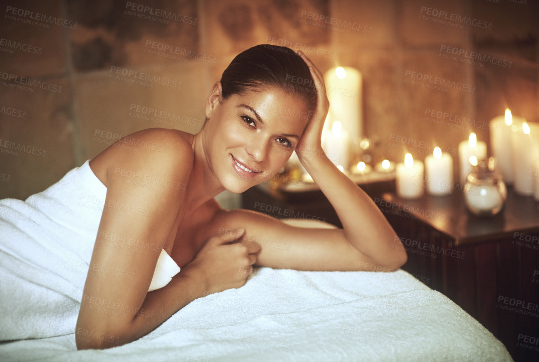 Buy stock photo Woman, portrait and relax at spa with candles for luxury treatment, zen and wellness on massage bed. Person, face and smile at beauty salon for skin therapy, body care and pamper session in resort