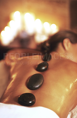Buy stock photo Massage, hot stones and back for woman, hands and detox for treatment at spa or salon. Rocks, beauty and body wellness for luxury service for female person, candles and relax for zen stress relief 