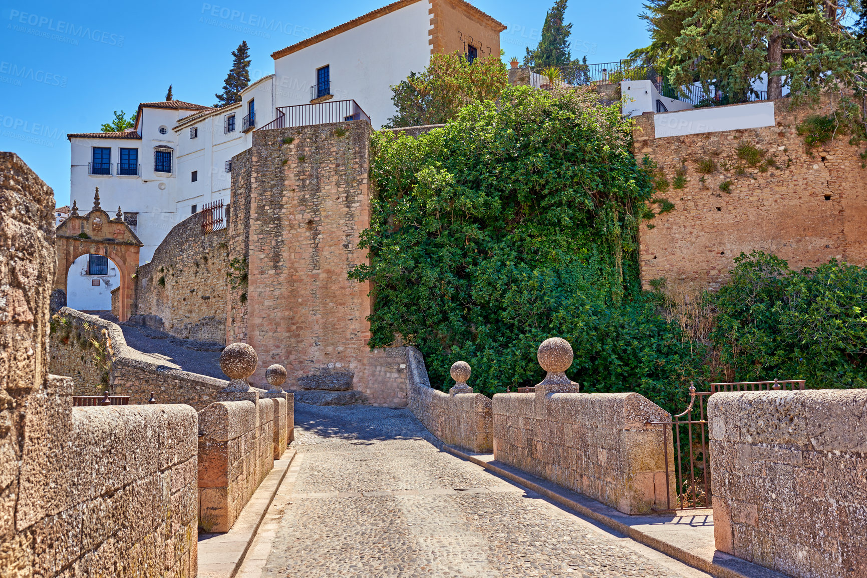 Buy stock photo Buildings, outdoor and bridge with architecture, travel and blue sky for holiday, traffic and aesthetic. History, pedestrian and infrastructure with tourism, sightseeing and vacation as town in Spain