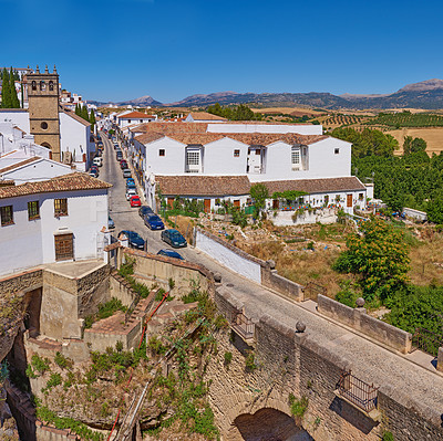 Buy stock photo Buildings, outdoor and bridge with architecture, pedestrian and blue sky for holiday, traffic and aesthetic. History, travel and infrastructure with tourism, sightseeing and vacation as town in Spain