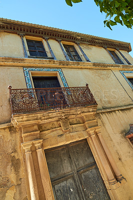 Buy stock photo Abandoned, house and balcony with wooden doors or window frames in rural town or city. Empty, wall and architecture with old concrete building, ancient or rustic structure of construction in Spain