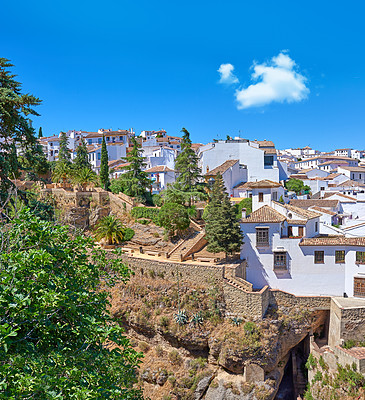 Buy stock photo Nature, buildings and city for travel, destination or holiday in Andalusia with vintage architecture. Location, blue sky and ancient houses outdoor in village for vacation, getaway or trip in Spain.