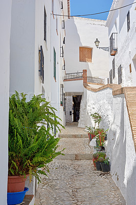 Buy stock photo Outdoor, houses and alley in neighborhood with traditional architecture in Spain. Outside, home and passage in village with cultural or vintage design as holiday or vacation destination for tourism