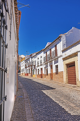 Buy stock photo Outdoor, houses and street  with traditional architecture in neighborhood of Spain. Outside, alley and road in village with cultural or vintage design as holiday or vacation destination for tourism