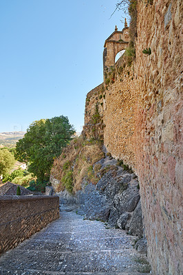 Buy stock photo Ancient, building and hill with steps architecture for wall structure, history location and culture monument. Pathway, stairs and colosseum museum with heritage travel, blue sky and vintage in Spain 