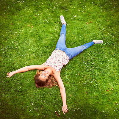 Buy stock photo High angle shot of a young woman relaxing on the grass