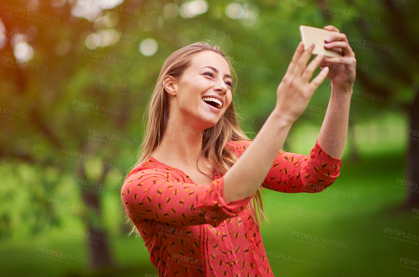 Buy stock photo Shot of a young woman taking a selfie outside