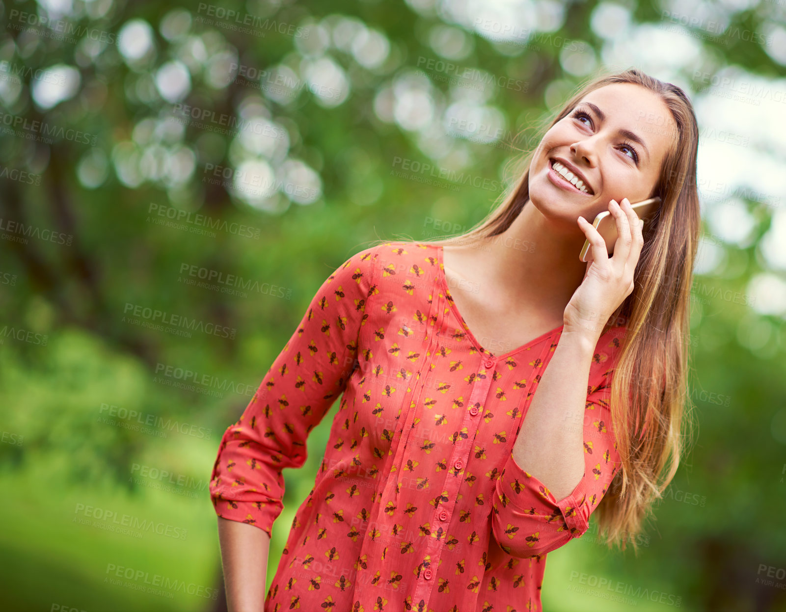 Buy stock photo Shot of a young woman talking on her cellphone outside