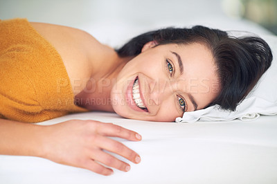 Buy stock photo Cropped portrait of a young woman lying on her bed