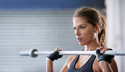 Buy stock photo Shot of a young woman working out with a barbell at the gym