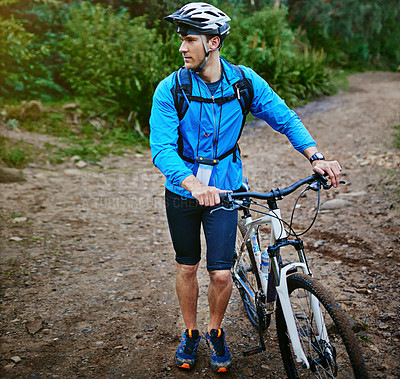Buy stock photo Shot of a male cyclist out for a ride on his mountain bike