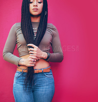 Buy stock photo Shot of a young woman with braids posing against a pink background
