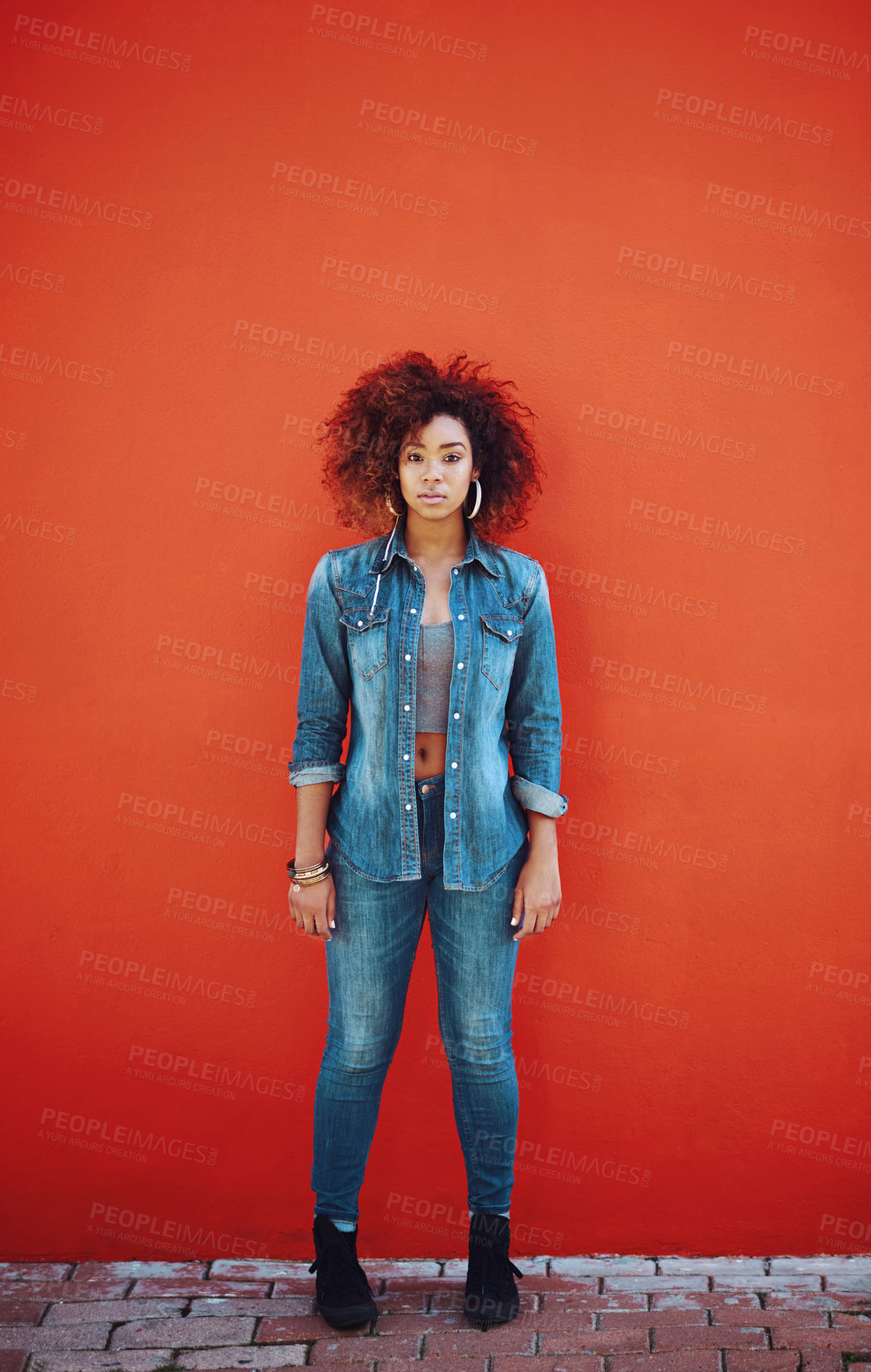 Buy stock photo Portrait of an attractive young woman posing in front of a red wall