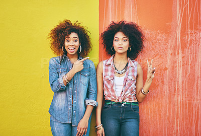 Buy stock photo Portrait of two young friends posing against a colorful background