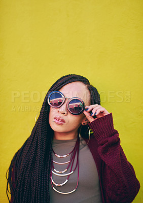 Buy stock photo Shot of a young woman wearing sunglasses against a green background