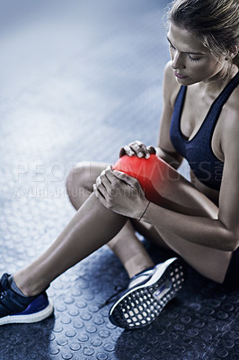 Buy stock photo Cropped shot of a young woman holding her injured knee that's highlighted in red