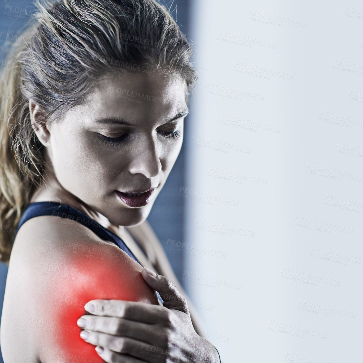 Buy stock photo Shot of a young woman holding her injured shoulder that's highlighted in red