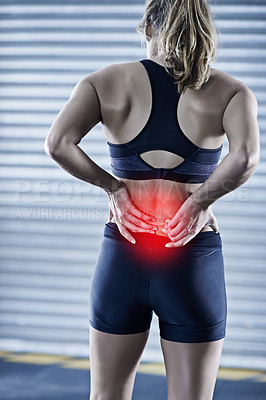 Buy stock photo Rearview shot of a young woman holding her injured back that's highlighted in red