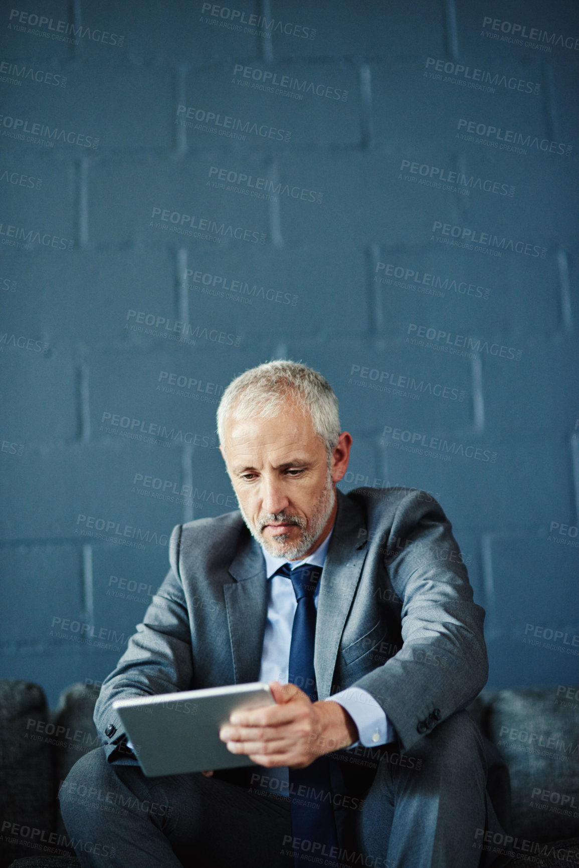 Buy stock photo Shot of a businessman using a digital tablet