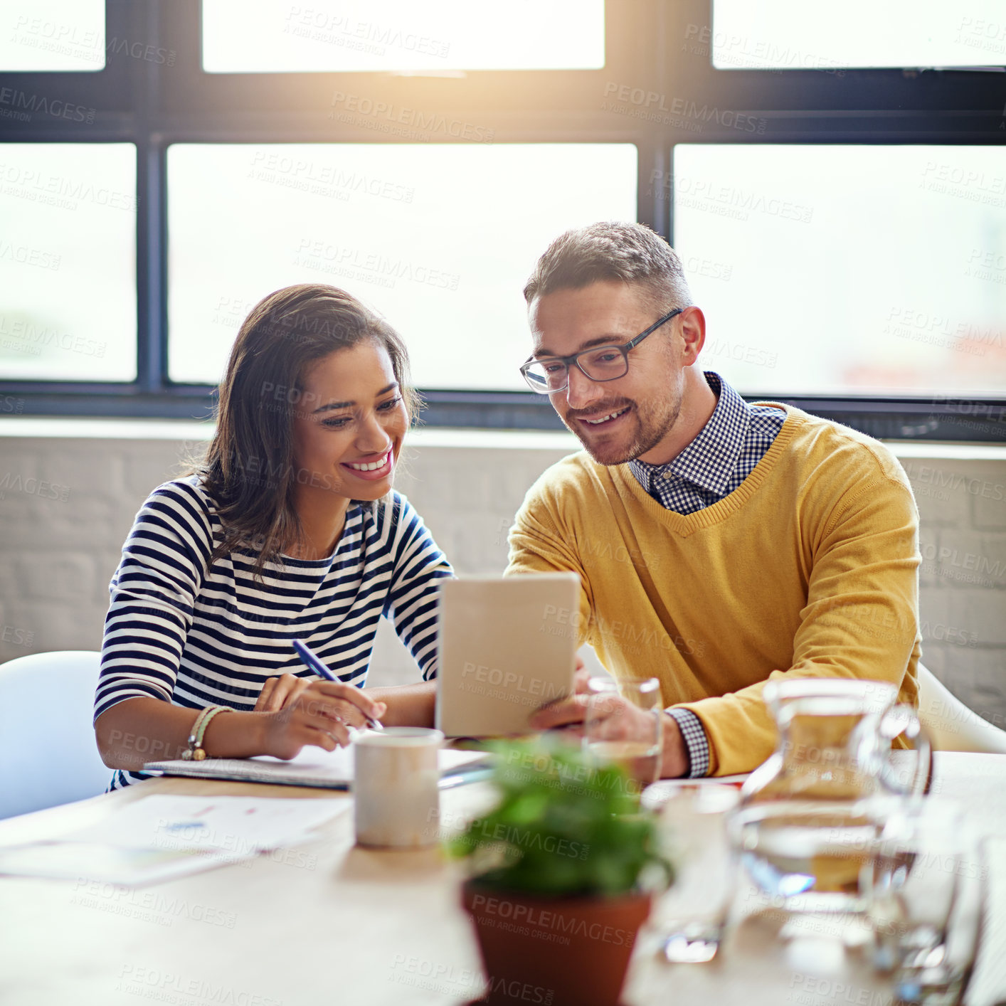 Buy stock photo Shot of two designers working on a digital tablet in an office