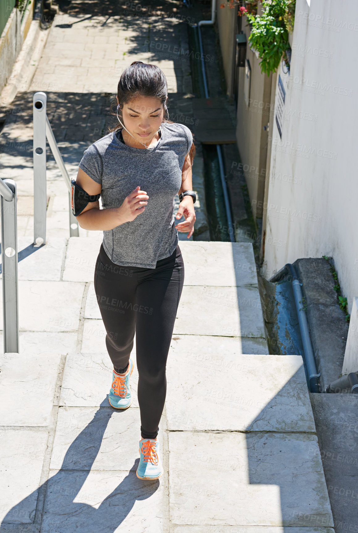 Buy stock photo Woman, runner and stairs with earphones for fitness, workout or cardio exercise in city. Female person or athlete running up steps with headphones for training or listening to music in an urban town