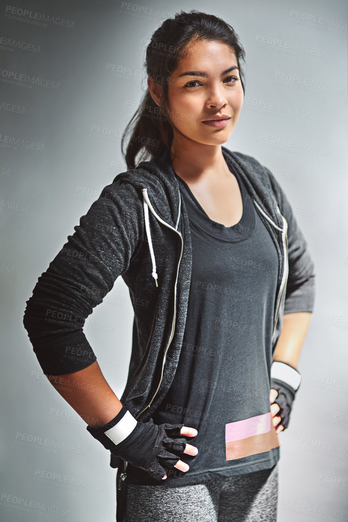 Buy stock photo Portrait of a fit young woman in sports clothing posing against a gray background