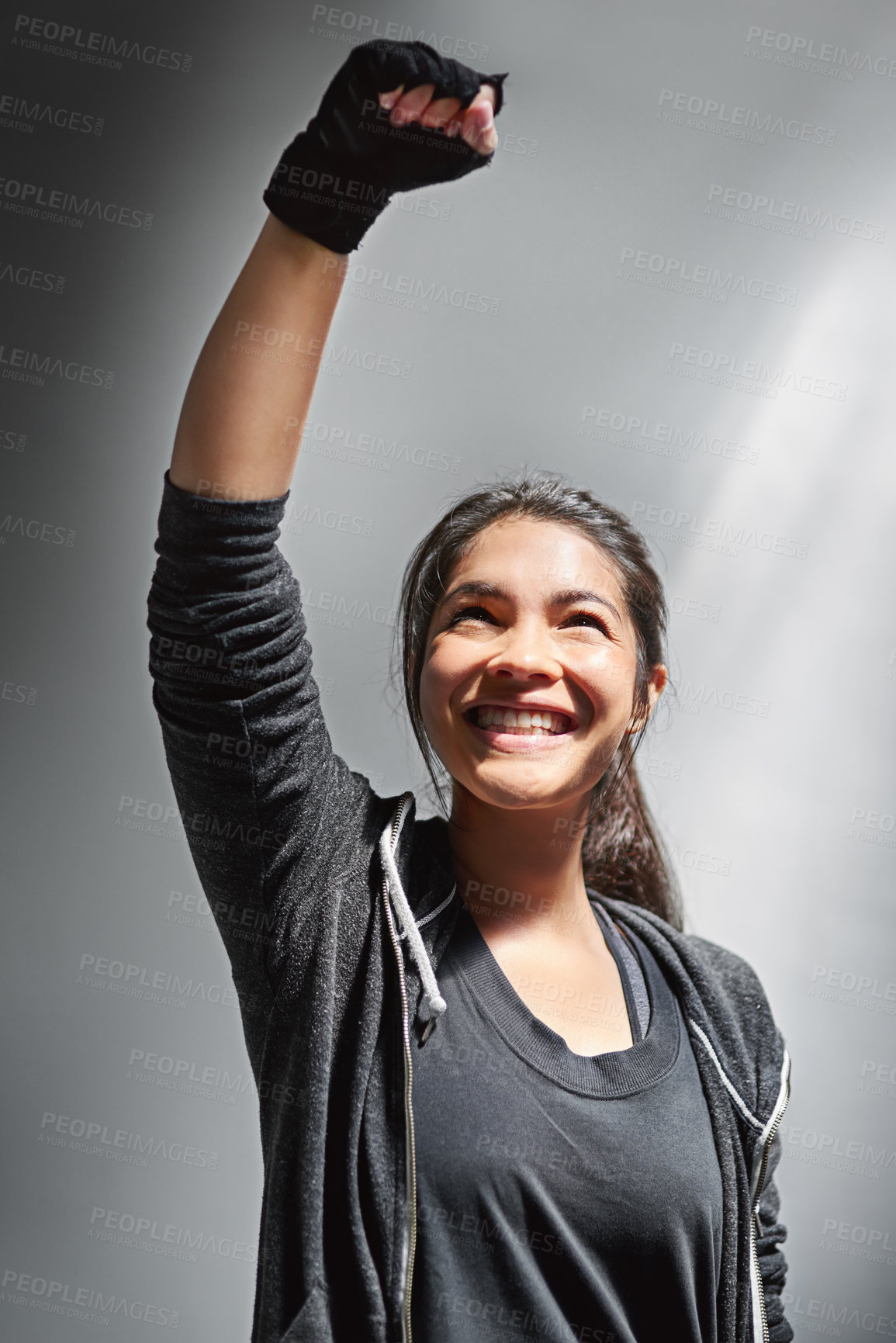 Buy stock photo Woman, fist and air for winning and fitness, success for training and gym on gray background. Celebration, smile and wellness goals for person, gloves and achievement with power gesture in studio