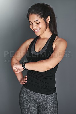 Buy stock photo Shot of a fit young woman in sports clothing checking her watch