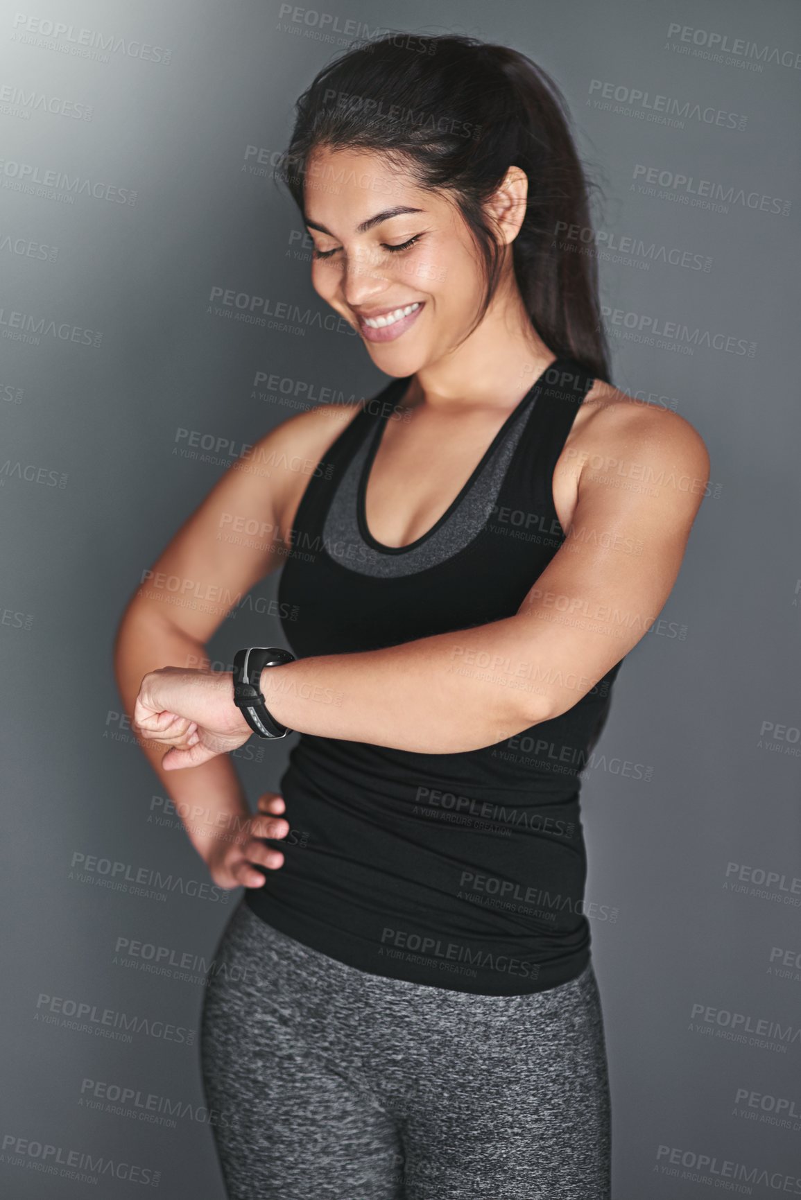 Buy stock photo Woman, fitness and check watch in studio to monitor exercise progress, workout challenge or timer for training. Athlete, happy or digital data for wellness, performance or time app on grey background