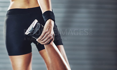 Buy stock photo Cropped rearview shot of a woman stretching her legs before a gym workout