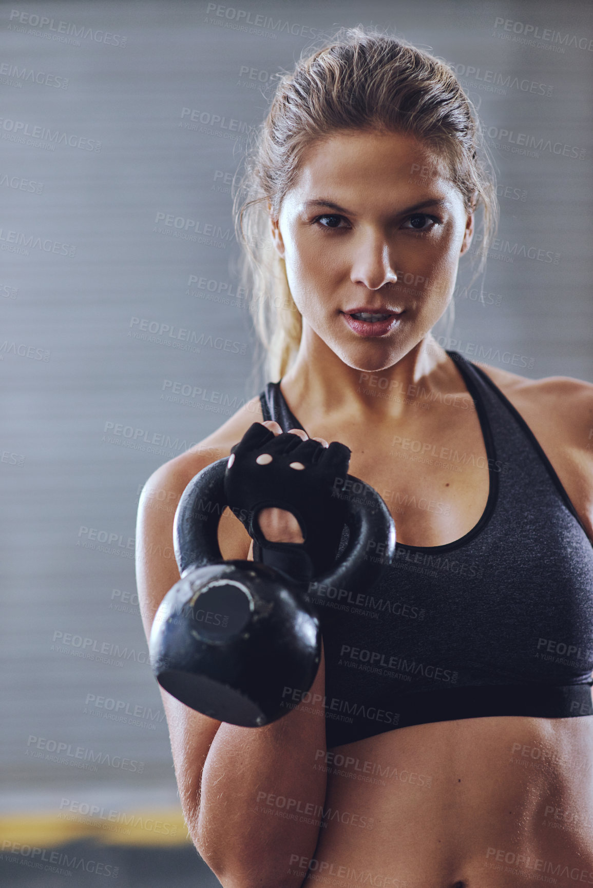 Buy stock photo Shot of a young woman working out with kettlebells